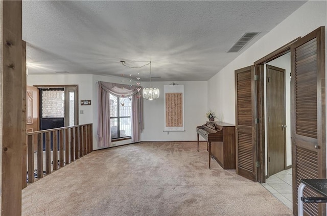 2301 S Stilwell St, Pittsburg, KS 66762 - unfurnished dining area with a chandelier, visible vents, a textured ceiling, and carpet floors