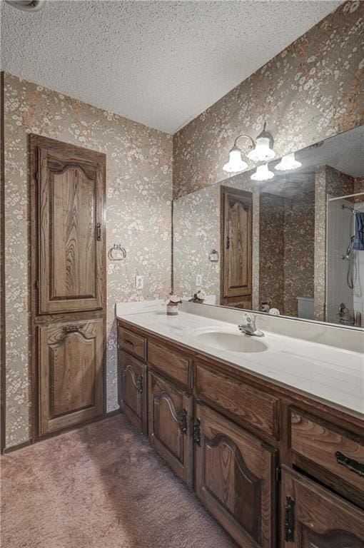 2301 S Stilwell St, Pittsburg, KS 66762 - bathroom with wallpapered walls, walk in shower, vanity, and a textured ceiling