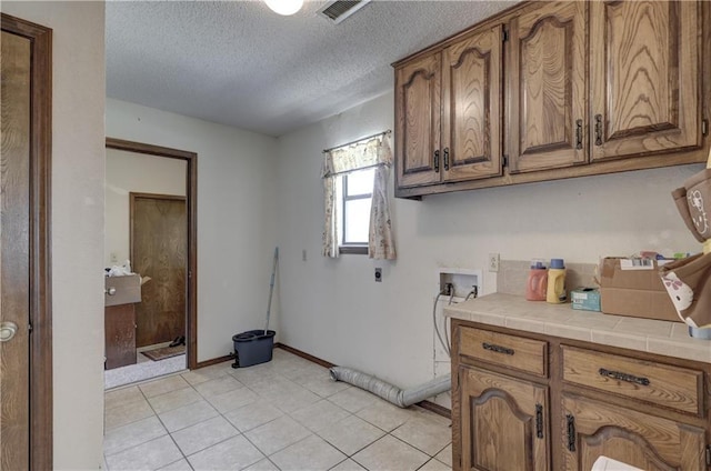 2301 S Stilwell St, Pittsburg, KS 66762 - clothes washing area featuring electric dryer hookup, a textured ceiling, visible vents, hookup for a washing machine, and cabinet space