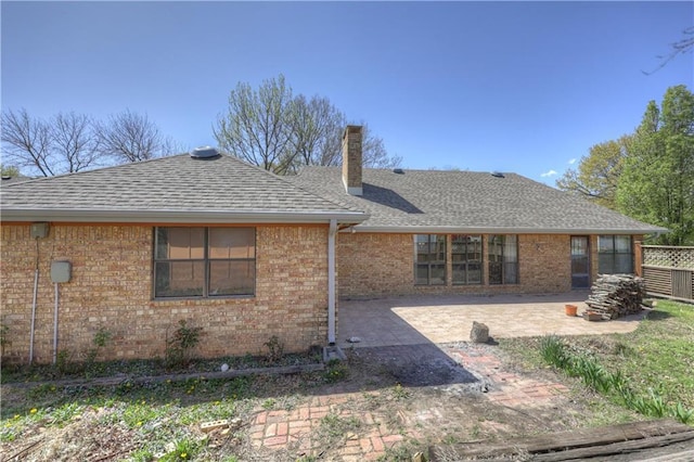 2301 S Stilwell St, Pittsburg, KS 66762 - rear view of house with a patio area, brick siding, a chimney, and a shingled roof