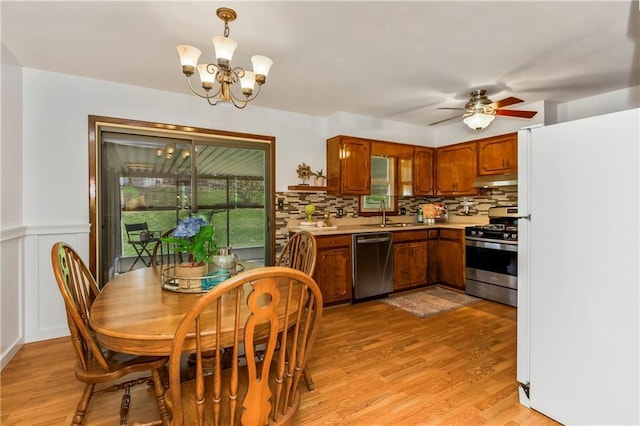kitchen featuring light wood-type flooring, stainless steel appliances, light countertops, and tasteful backsplash