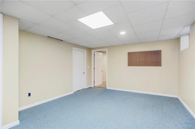 finished basement with baseboards, carpet floors, and a drop ceiling