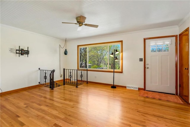 foyer entrance featuring crown molding, light wood finished floors, visible vents, and plenty of natural light