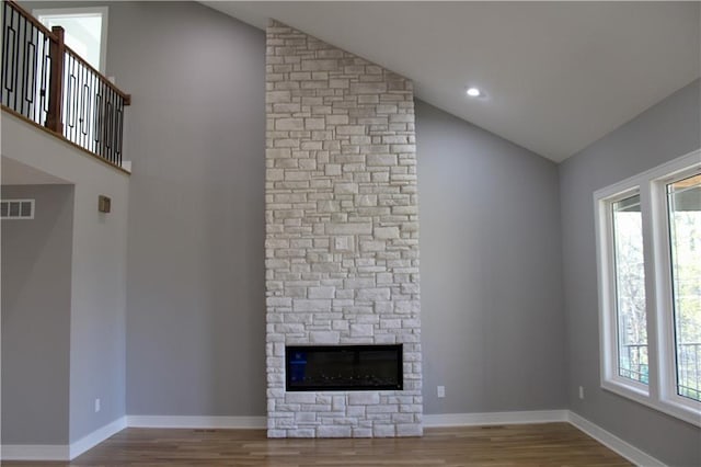 unfurnished living room with a healthy amount of sunlight, visible vents, and wood finished floors