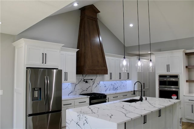 kitchen featuring open shelves, a sink, appliances with stainless steel finishes, white cabinetry, and a center island with sink