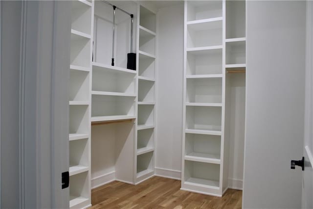 walk in closet with wood finished floors