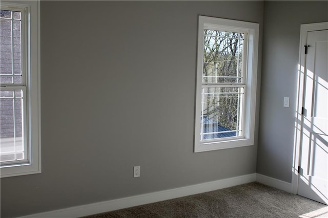 carpeted empty room featuring baseboards