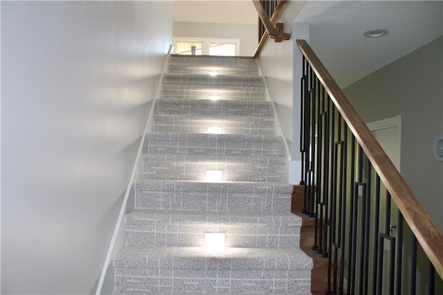 staircase featuring baseboards and granite finish floor