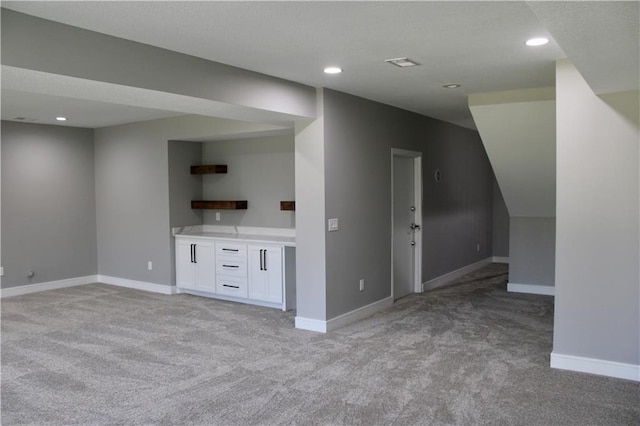 unfurnished living room featuring recessed lighting, light colored carpet, and baseboards