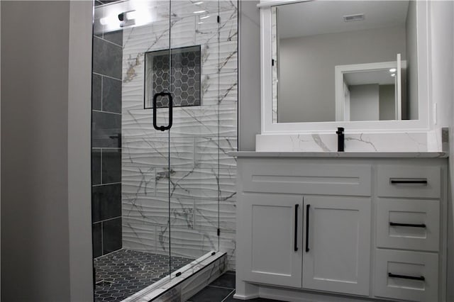full bathroom featuring a stall shower, vanity, and visible vents