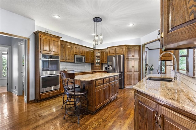 5316 NE Northgate Xing, Lees Summit, MO 64064 - kitchen featuring stainless steel appliances, a sink, light stone counters, tasteful backsplash, and plenty of natural light