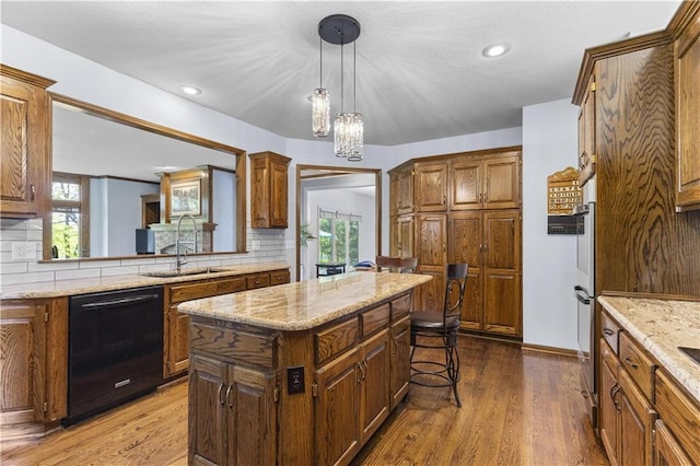 5316 NE Northgate Xing, Lees Summit, MO 64064 - kitchen with black dishwasher, a breakfast bar, backsplash, a kitchen island, and a sink