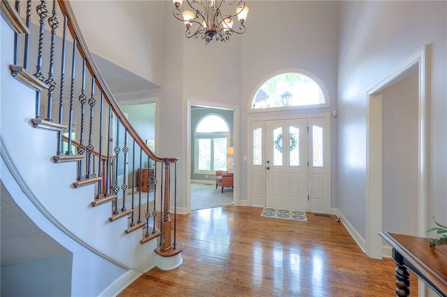 5316 NE Northgate Xing, Lees Summit, MO 64064 - foyer featuring a high ceiling, a chandelier, stairs, wood finished floors, and baseboards