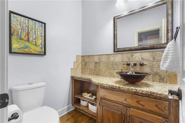 5316 NE Northgate Xing, Lees Summit, MO 64064 - half bath featuring vanity, baseboards, toilet, decorative backsplash, and wood finished floors