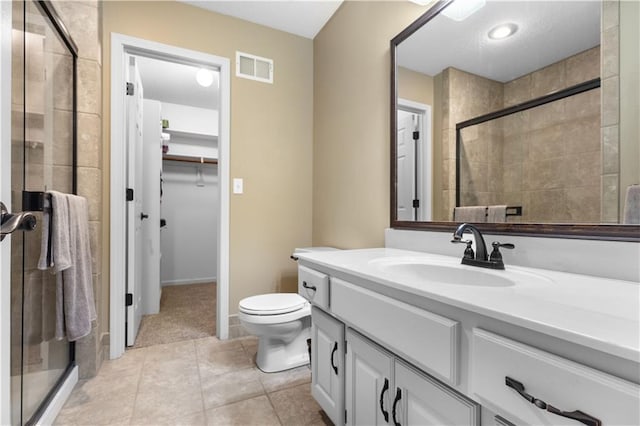 5316 NE Northgate Xing, Lees Summit, MO 64064 - full bathroom featuring vanity, a walk in closet, a stall shower, tile patterned flooring, and toilet