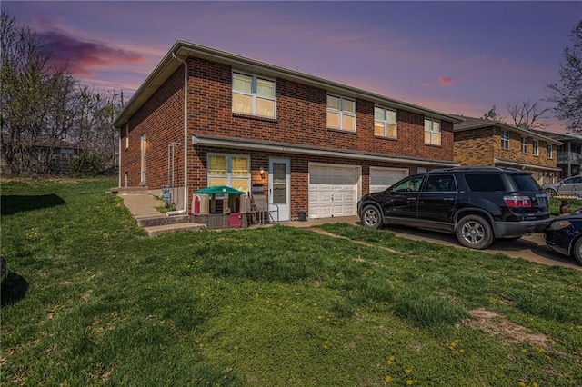 3520 S Lynn St, Independence, MO 64055 - townhome / multi-family property featuring a yard, a garage, driveway, and brick siding