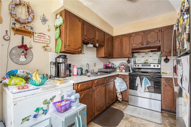 3520 S Lynn St, Independence, MO 64055 - kitchen with tasteful backsplash, stainless steel range with electric stovetop, under cabinet range hood, light countertops, and a sink