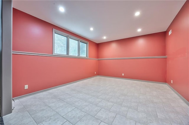 spare room with recessed lighting and baseboards