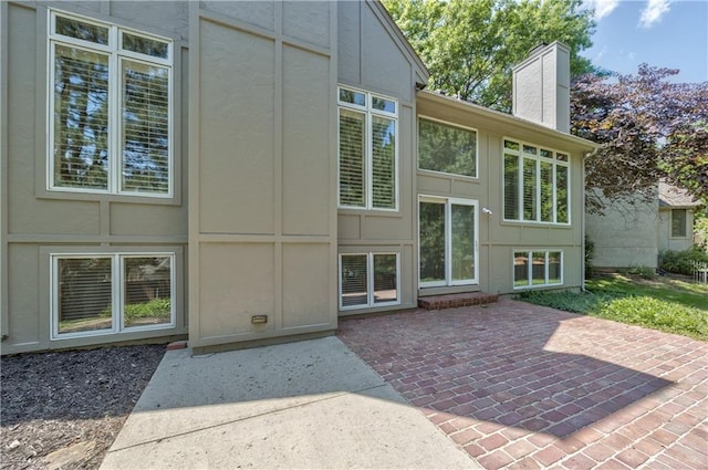 5400 W 97th Cir W, Overland Park, KS 66207 - rear view of property featuring a chimney, a patio, and stucco siding