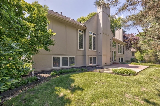 5400 W 97th Cir W, Overland Park, KS 66207 - rear view of house with a chimney, a patio area, a lawn, and stucco siding