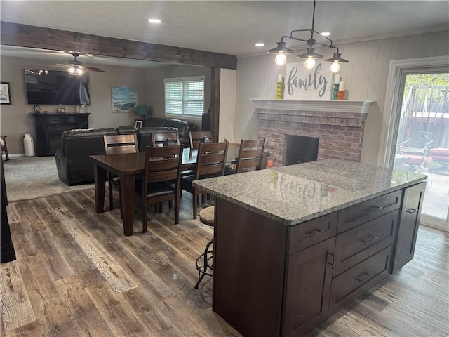 kitchen with a brick fireplace, a ceiling fan, a wealth of natural light, and open floor plan