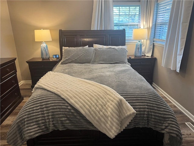 bedroom with dark wood-style floors and baseboards