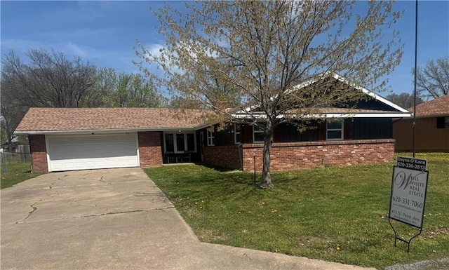 ranch-style home with a garage, brick siding, driveway, and a front yard