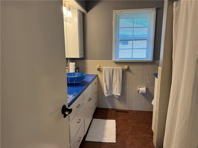 912 Circle Dr, Independence, KS 67301 - full bathroom featuring tile walls, tile patterned flooring, vanity, curtained shower, and wainscoting