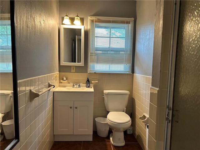 912 Circle Dr, Independence, KS 67301 - bathroom with toilet, tile walls, tile patterned flooring, vanity, and wainscoting