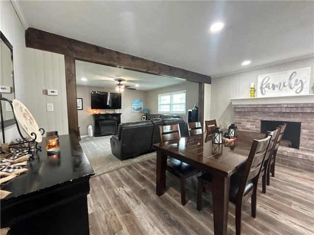 912 Circle Dr, Independence, KS 67301 - dining room with a brick fireplace, ceiling fan, wood finished floors, recessed lighting, and beamed ceiling