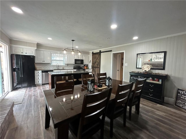 912 Circle Dr, Independence, KS 67301 - dining space with a barn door, ornamental molding, and dark wood-style floors