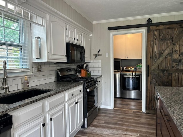 912 Circle Dr, Independence, KS 67301 - kitchen with gas range, black microwave, a sink, separate washer and dryer, and crown molding