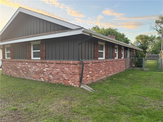 912 Circle Dr, Independence, KS 67301 - view of side of property featuring brick siding, a gate, board and batten siding, and a chimney