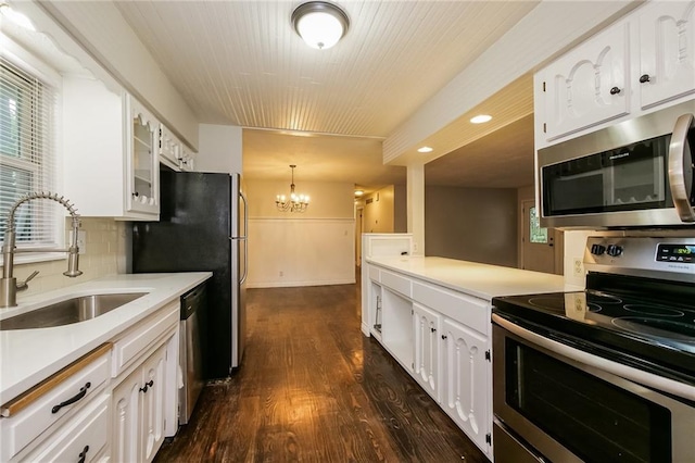 kitchen featuring a sink, light countertops, a chandelier, stainless steel appliances, and dark wood-type flooring