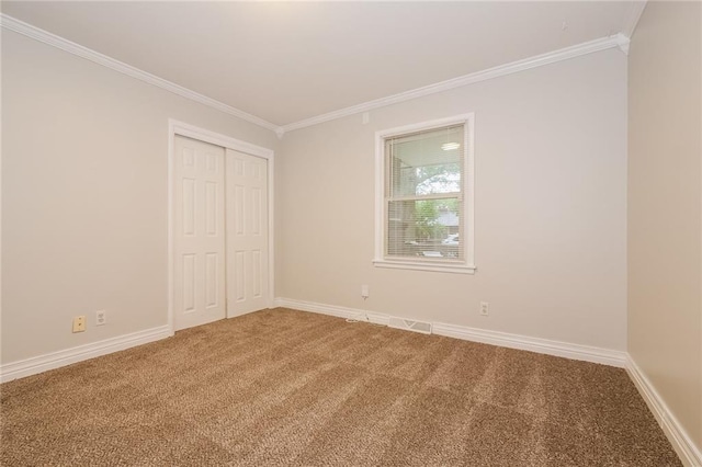 unfurnished room featuring ornamental molding, baseboards, and carpet floors