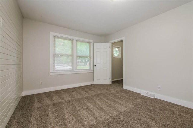 carpeted spare room with baseboards and visible vents
