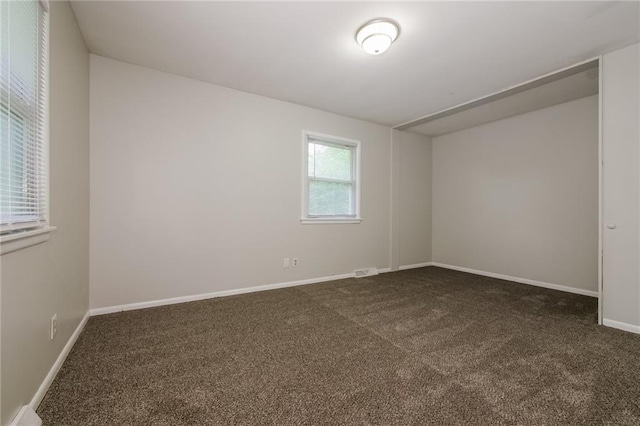 carpeted spare room featuring visible vents and baseboards