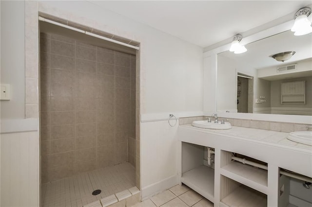 full bathroom with a sink, visible vents, tiled shower, and tile patterned flooring