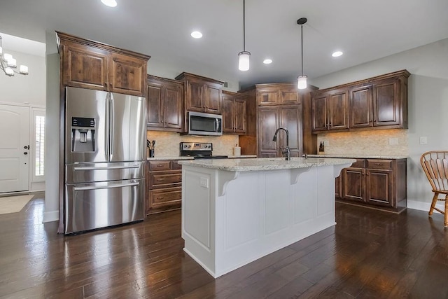 kitchen featuring light stone countertops, appliances with stainless steel finishes, dark wood finished floors, recessed lighting, and decorative backsplash