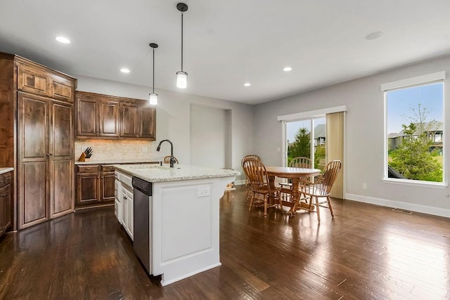 kitchen featuring a healthy amount of sunlight, a sink, tasteful backsplash, and dishwasher