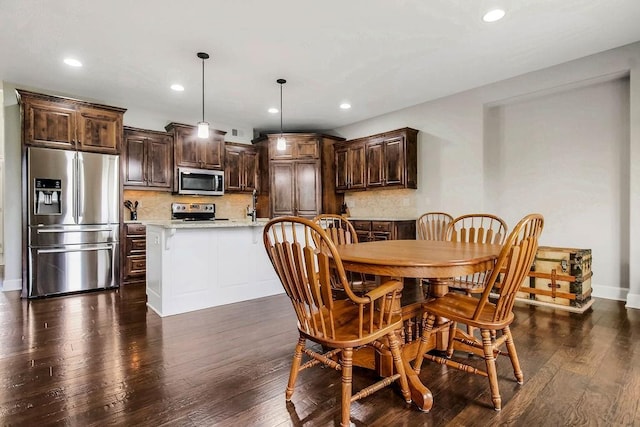 dining room with recessed lighting, baseboards, and dark wood-style floors