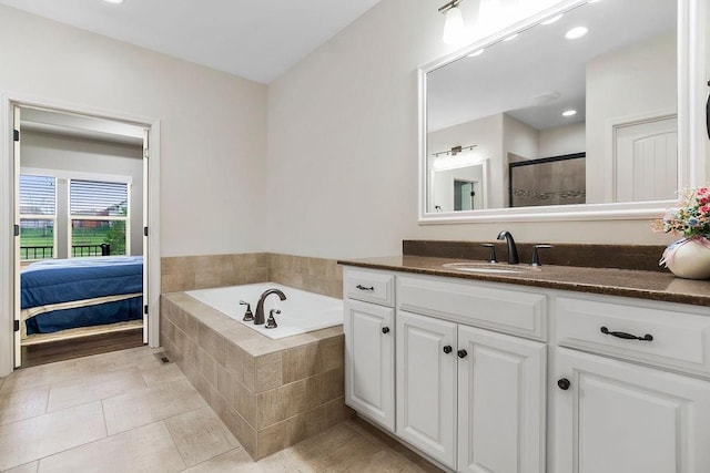 bathroom featuring a garden tub, a stall shower, vanity, tile patterned floors, and recessed lighting
