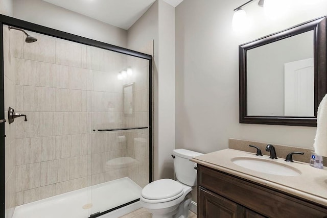 bathroom with vanity, toilet, and a stall shower