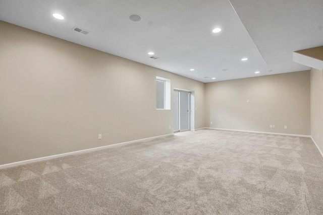 spare room with light colored carpet, baseboards, visible vents, and recessed lighting