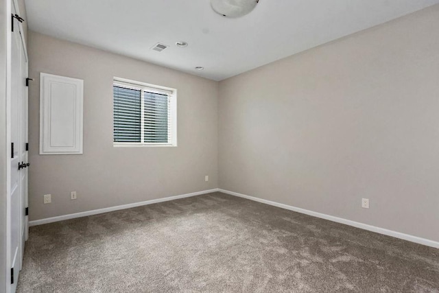 spare room featuring carpet floors, baseboards, and visible vents