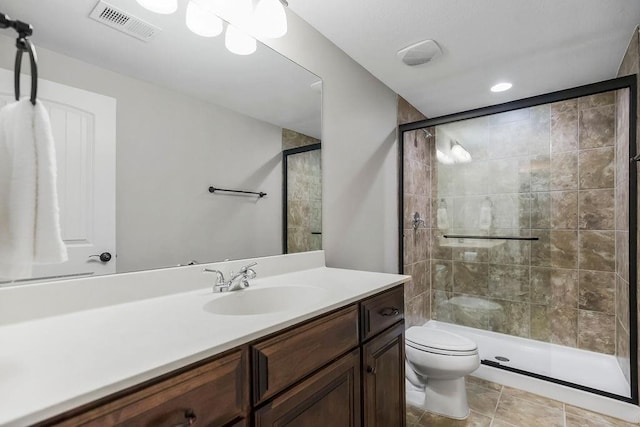 bathroom featuring visible vents, a stall shower, toilet, and vanity