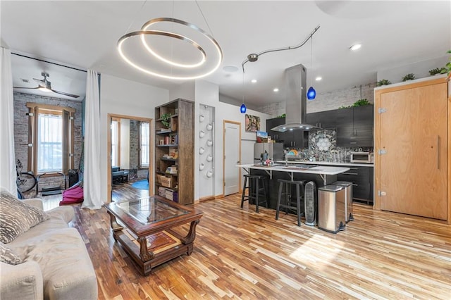 living area featuring ceiling fan, recessed lighting, and light wood-style floors
