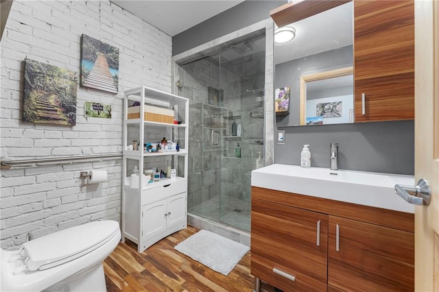 bathroom with toilet, a shower stall, vanity, and wood finished floors
