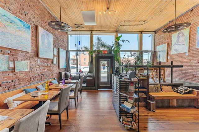 dining room with a wall of windows, hardwood / wood-style flooring, brick wall, and wood ceiling