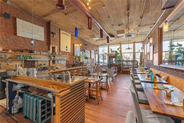 interior space with brick wall, wood-type flooring, and wooden ceiling